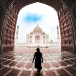 Immersi nella Scena: Foto con GoPro al Taj Mahal, la Ragazza che Avanza attraverso il Portone dando le spalle al Taj Mahal, offere un'Esperienza che Trasmette la Sensazione di Essere Presenti in Quel Momento Magico.